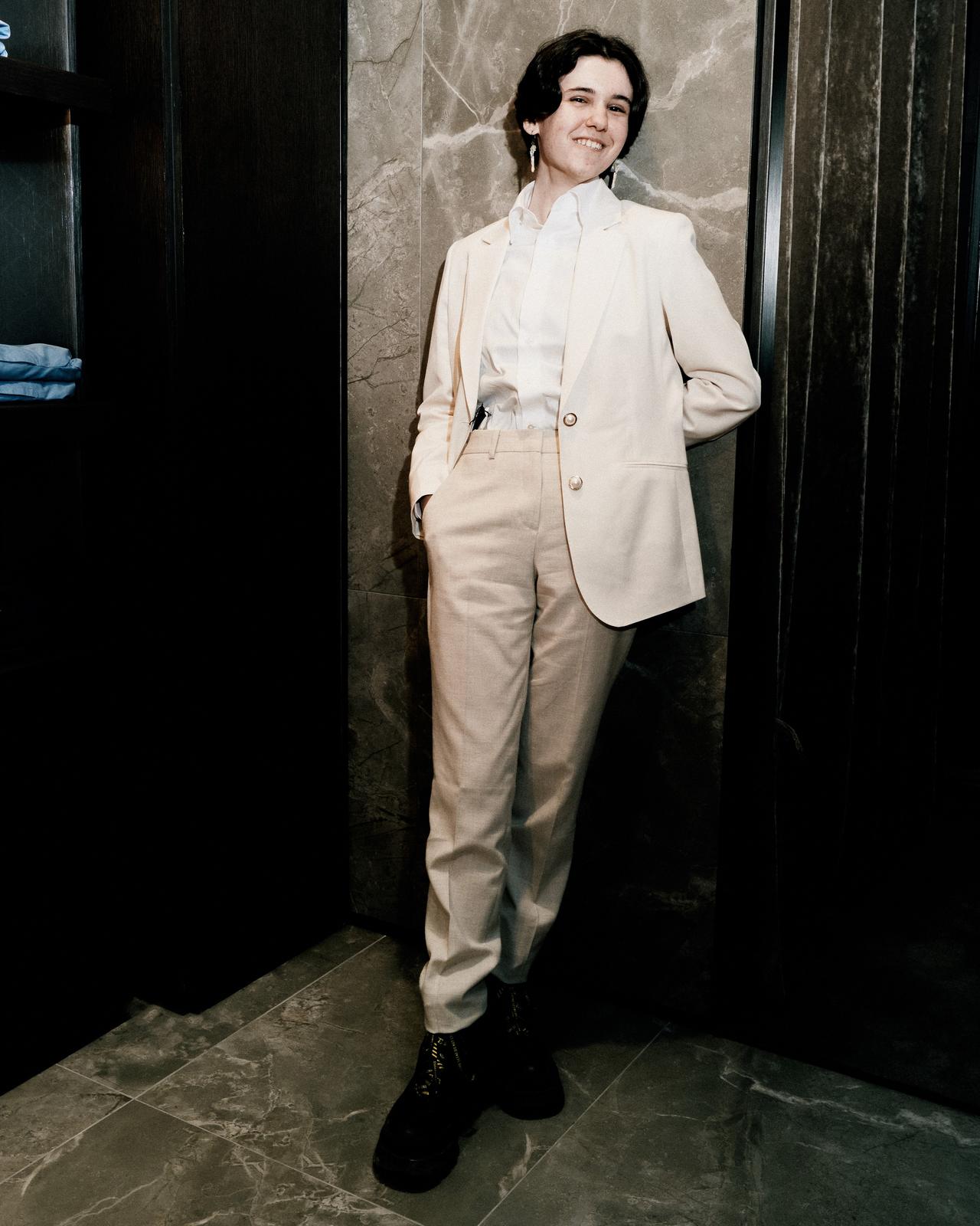 a person in a white suit standing in a room