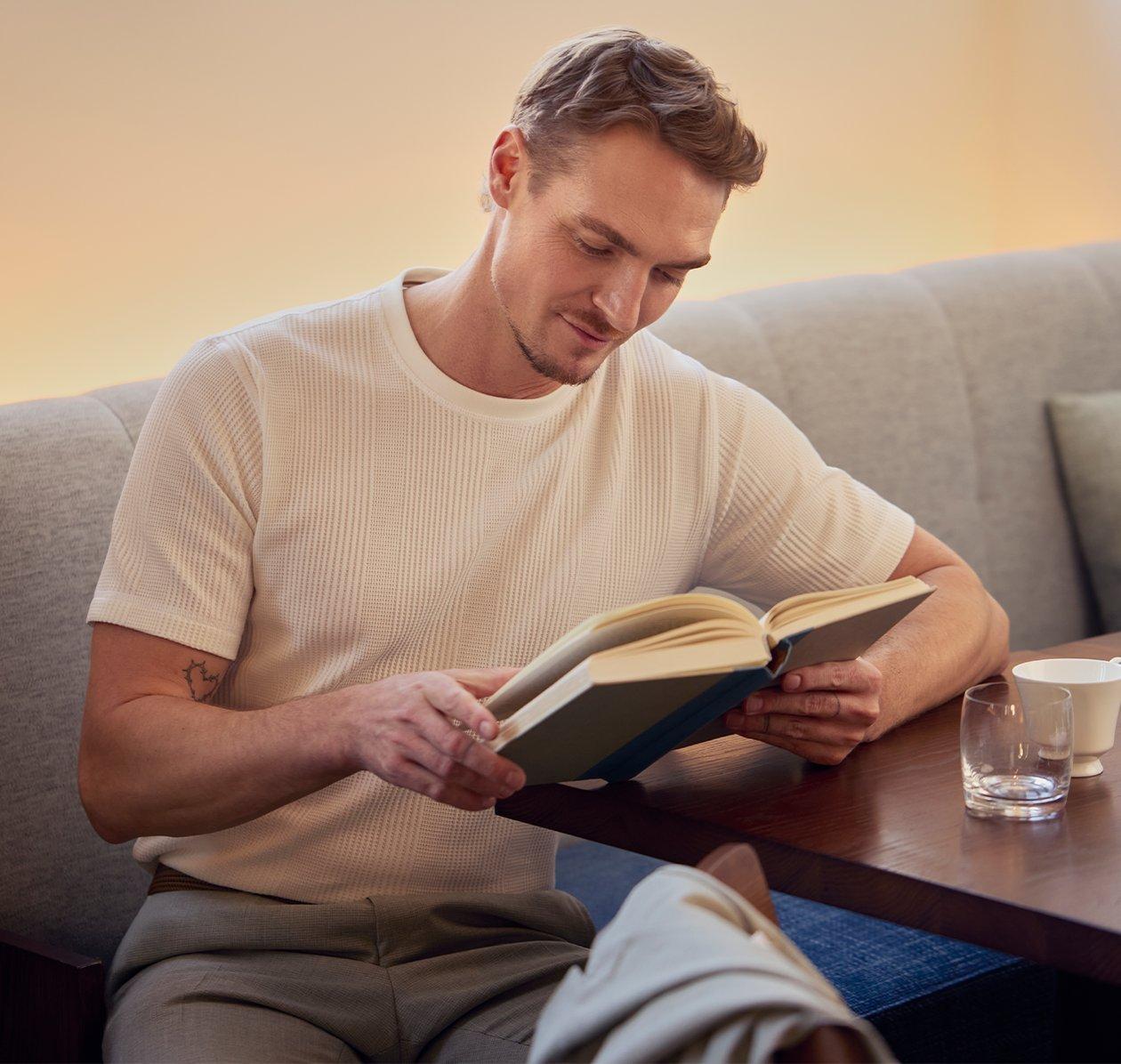 A model sitting at a table reading a book