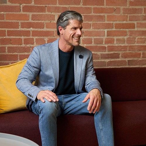 Male model wearing sweater, sport jacket and chinos signifying capsule wardrobe