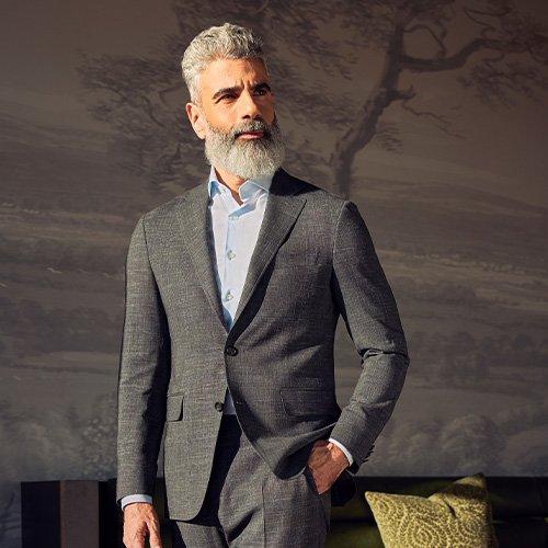 Male model wearing a grey suit and sky blue dress shirt