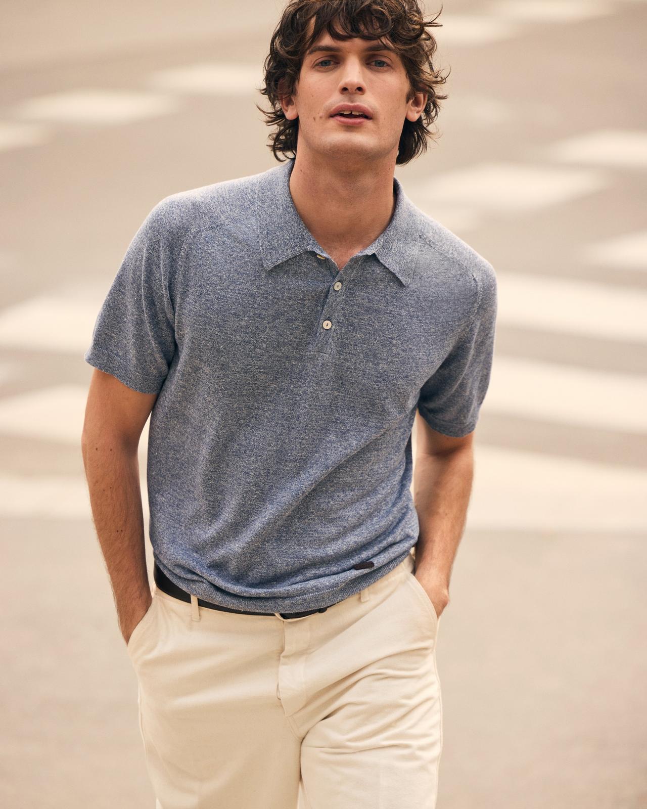 A man wearing a dark purle-gray polo t-shirt