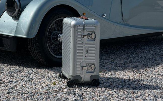 Une valise cabine argentée unique dans un champ de fleurs