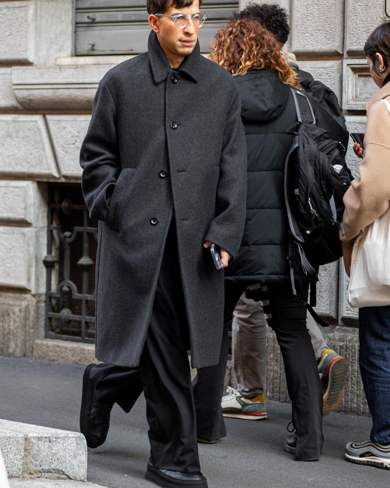Un homme marchant dans une rue avec un téléphone portable à la main