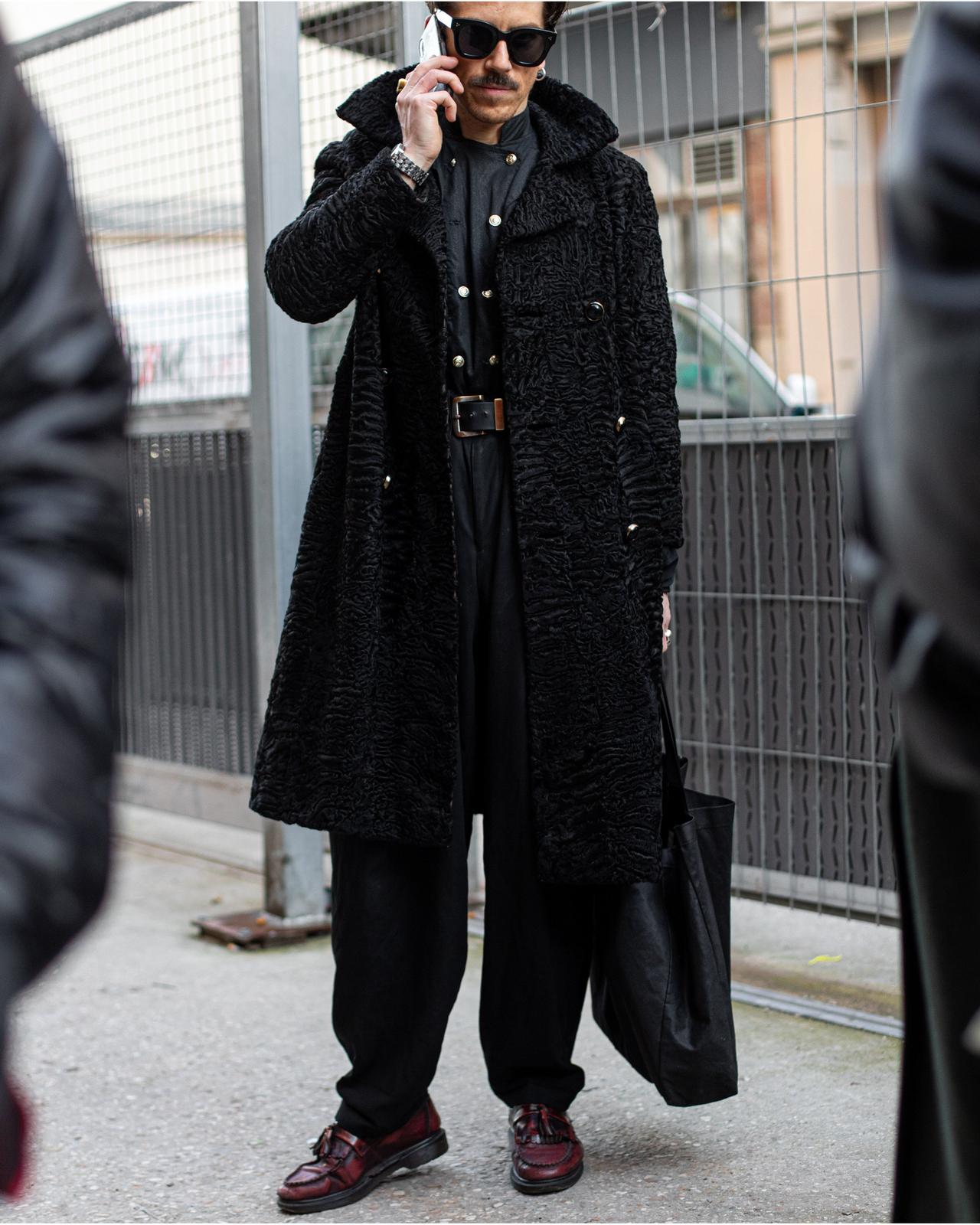 A man in a black coat talking on a cell phone