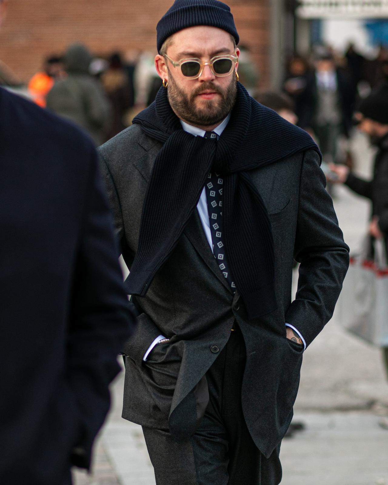 A man in a suit and tie walking down a city street