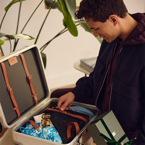 Man packing suitcase for a tropical holiday vacation