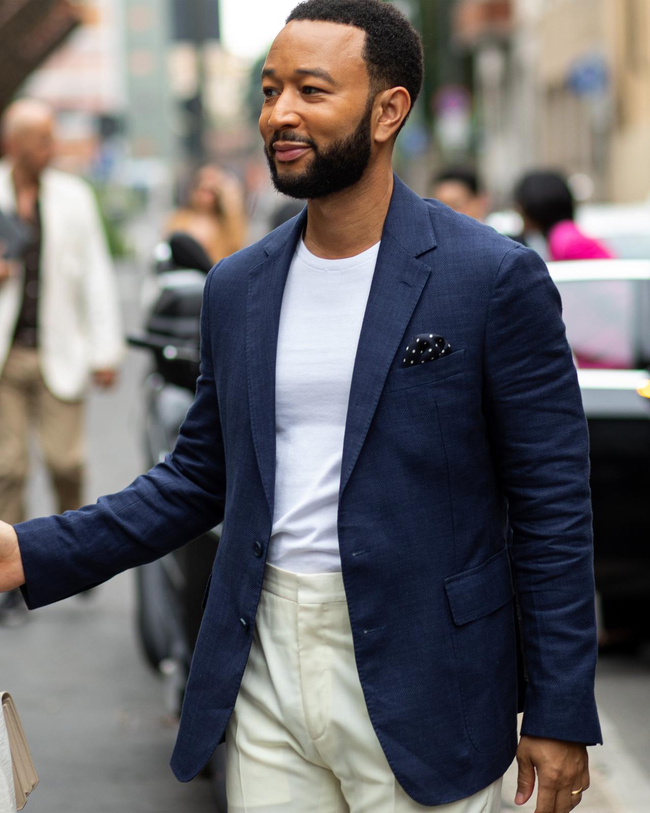 john legend walking in street in sport jacket, t-shirt and dress pants