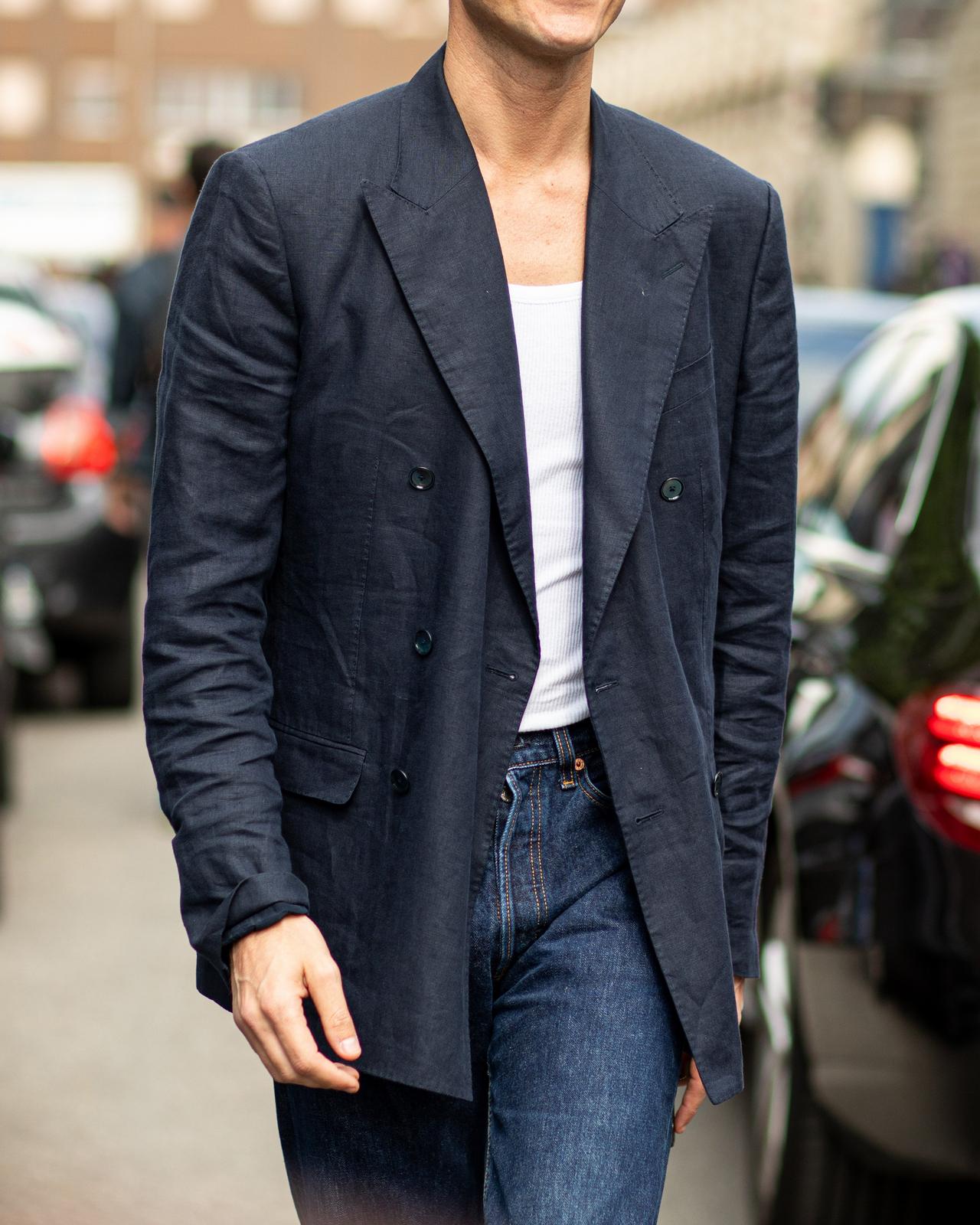 male walking in the street wearing sport jacket,t-shirt and jeans