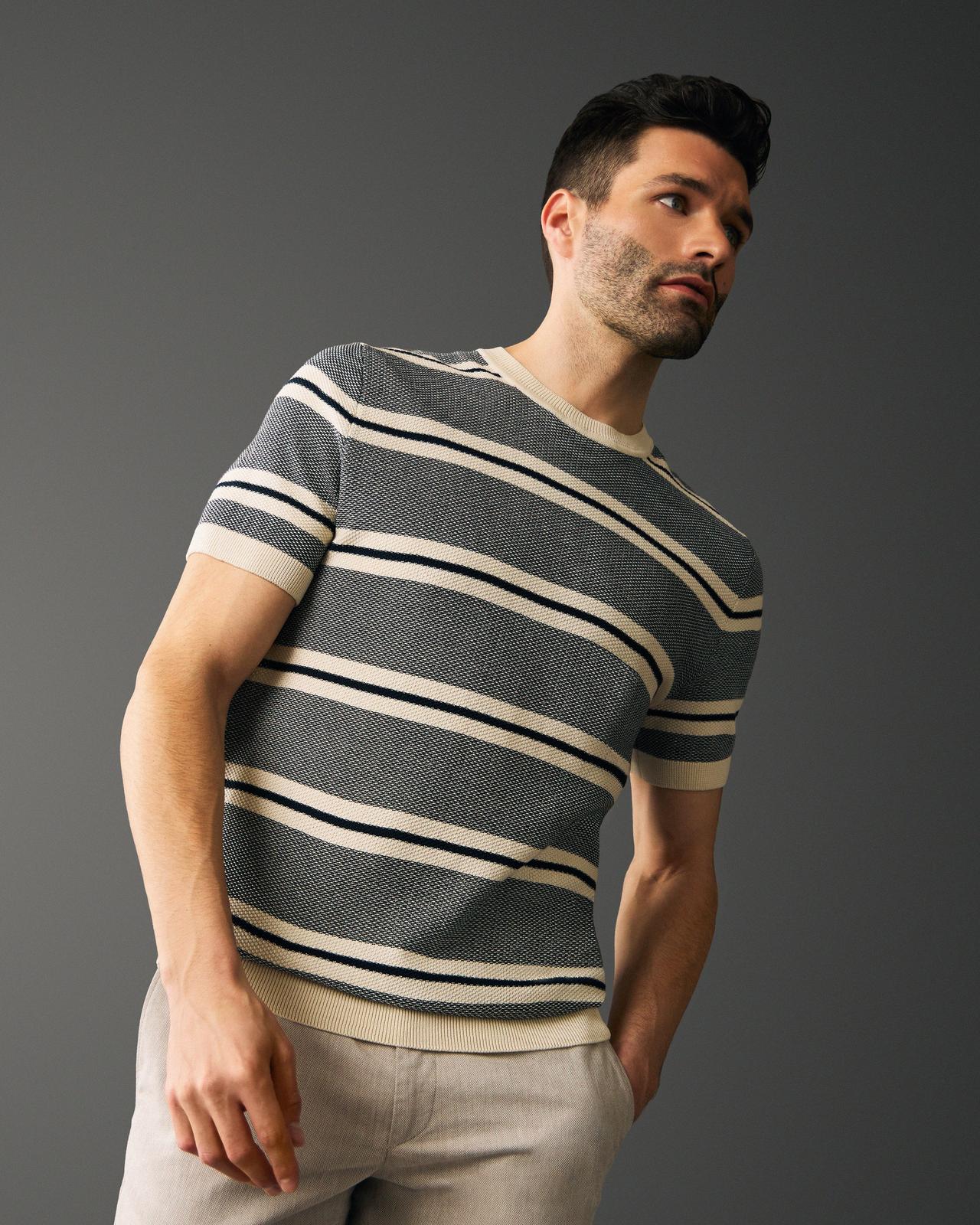a man in a striped t-shirt leaning back