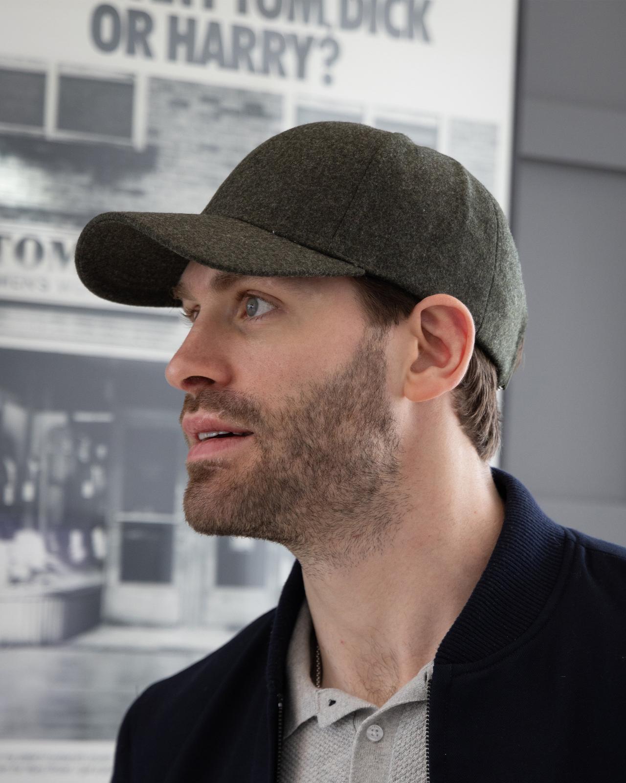 A man in a baseball cap looking at a poster of a man