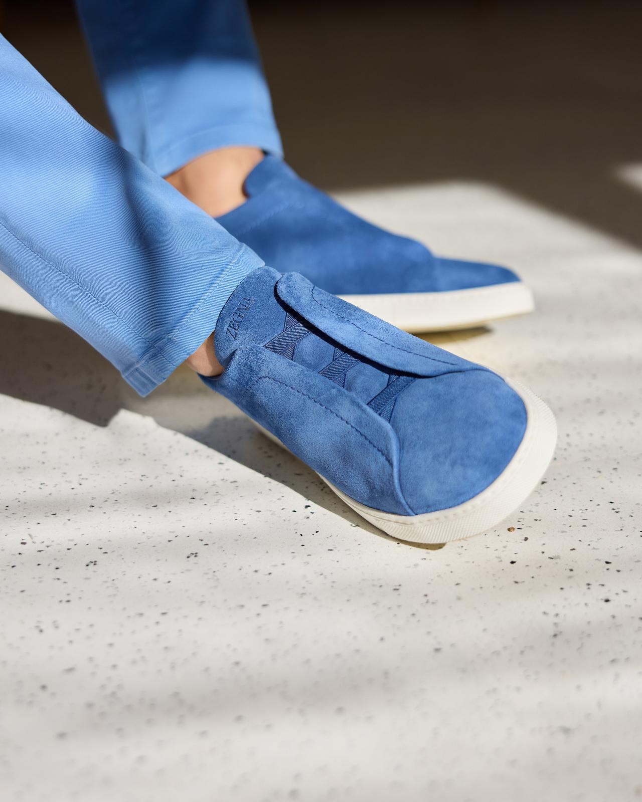 gros plan d'un homme portant des baskets triple point Zegna bleu vif