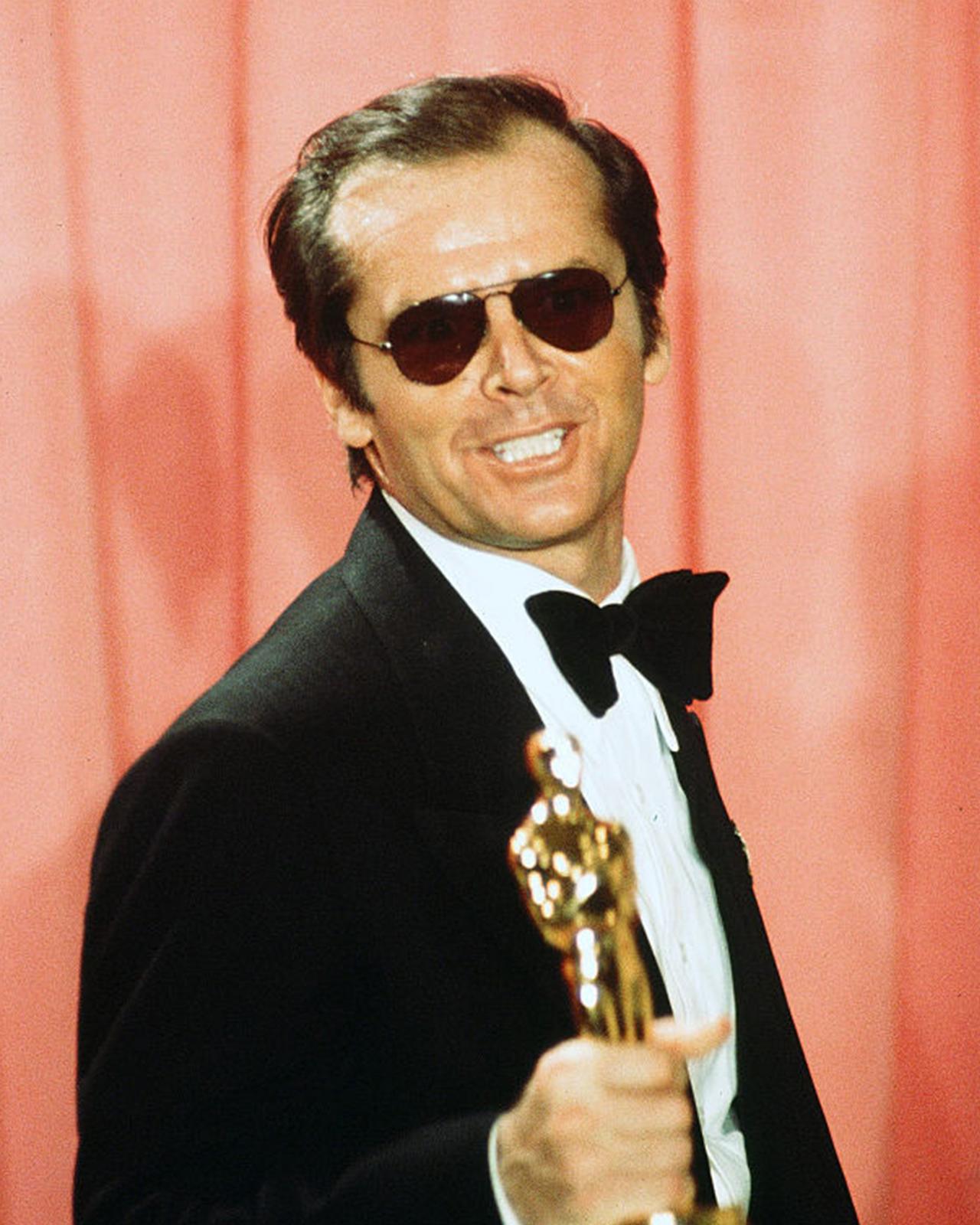 Jack Nicolson in a tuxedo holding an oscar statue