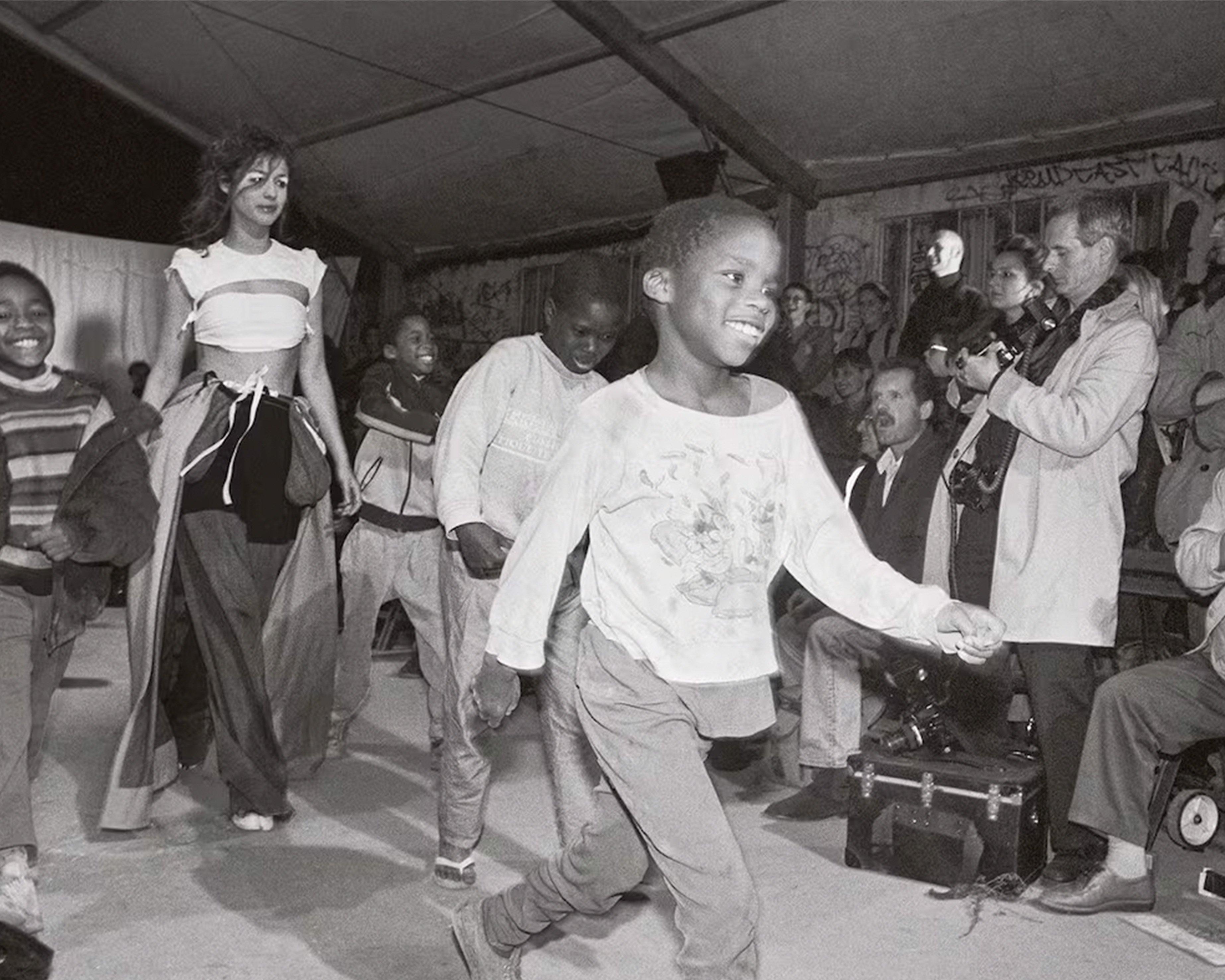black and white photo of a child running on a fashion runway
