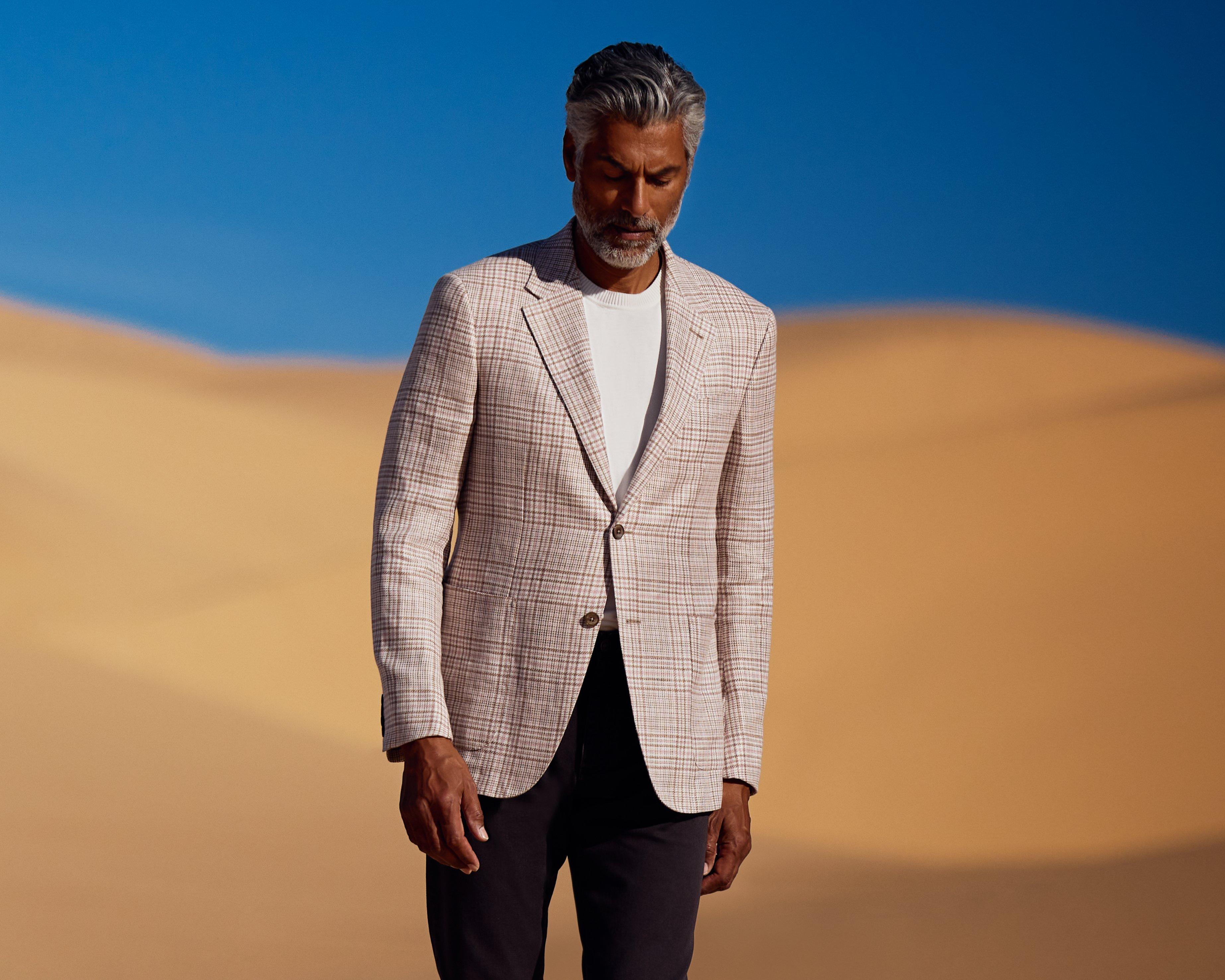 A man in a Zegna suit walking in the desert