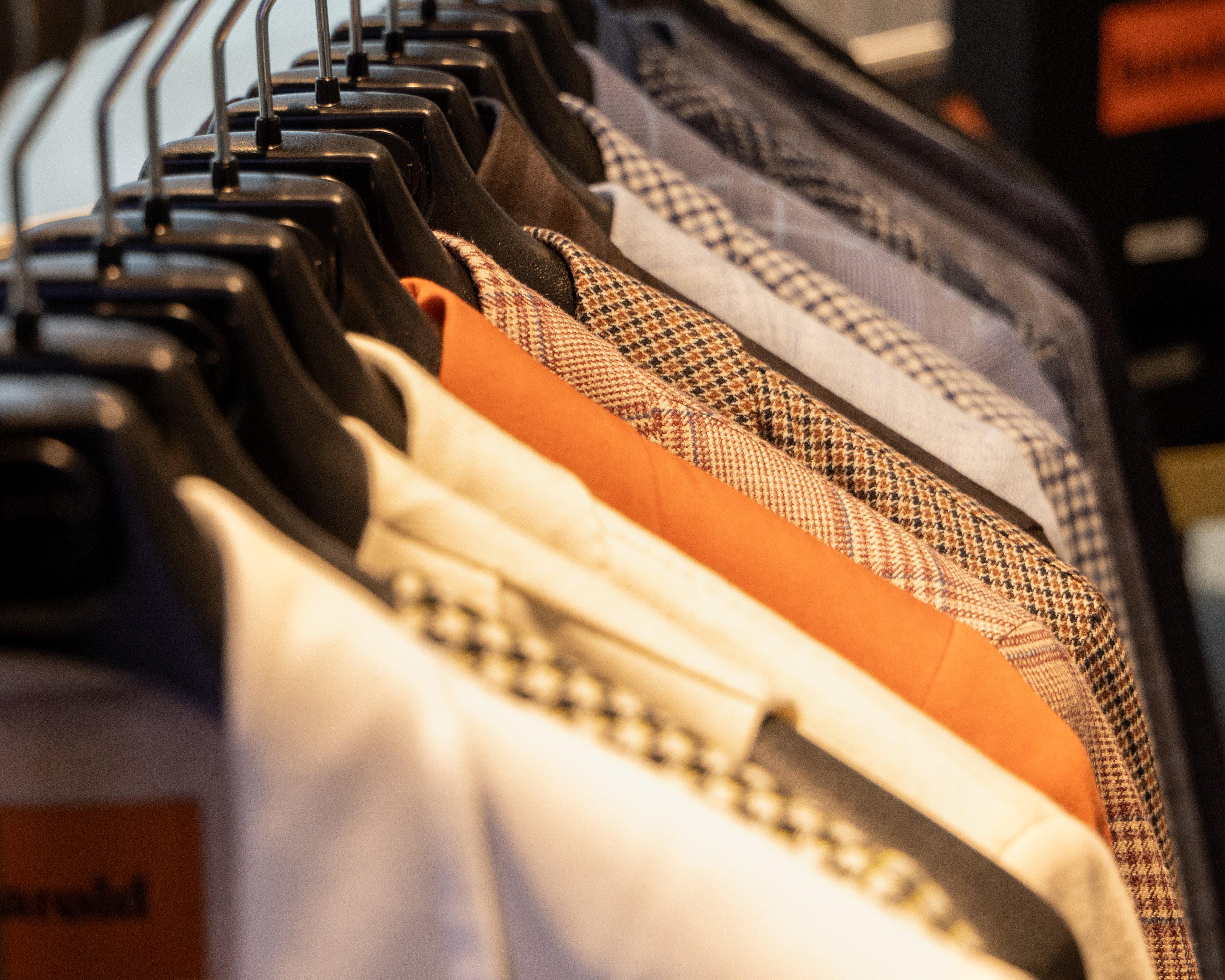 A rack of men's shirts and ties hanging on a rack