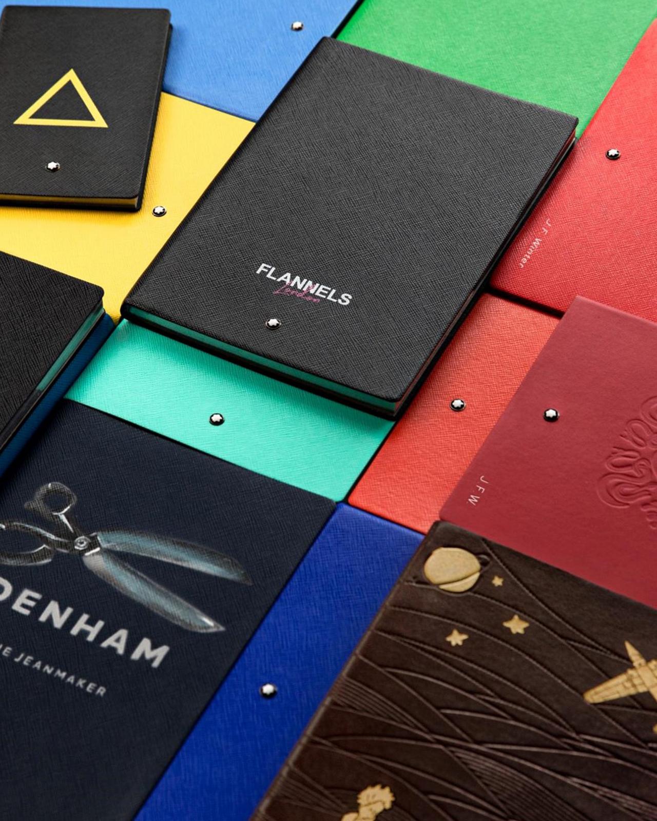 a variety of different colored notebooks and folders on a table