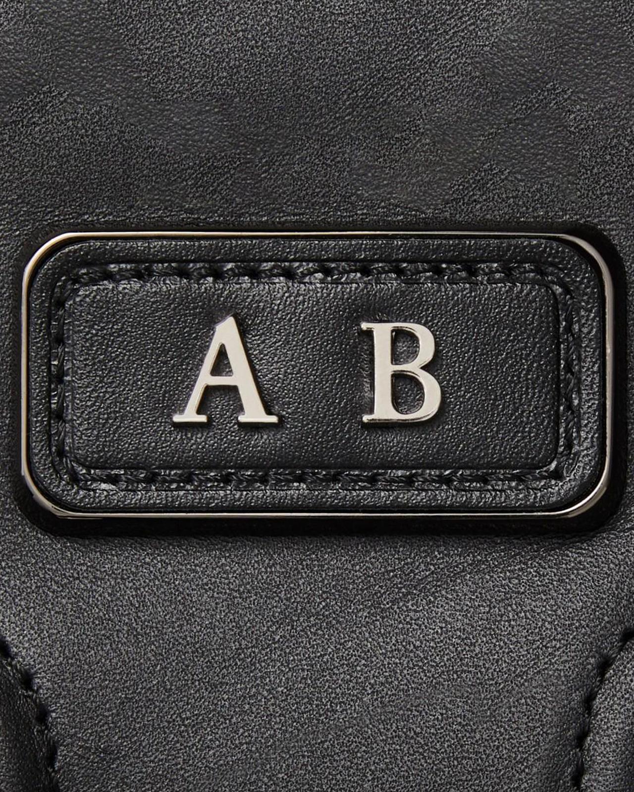 the monogrammed initials on a black leather bag