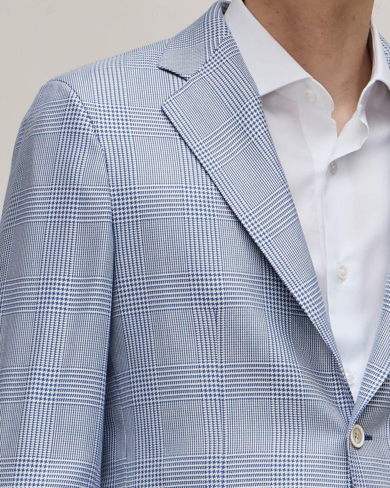 A man in a blue blazer and white checkered suit