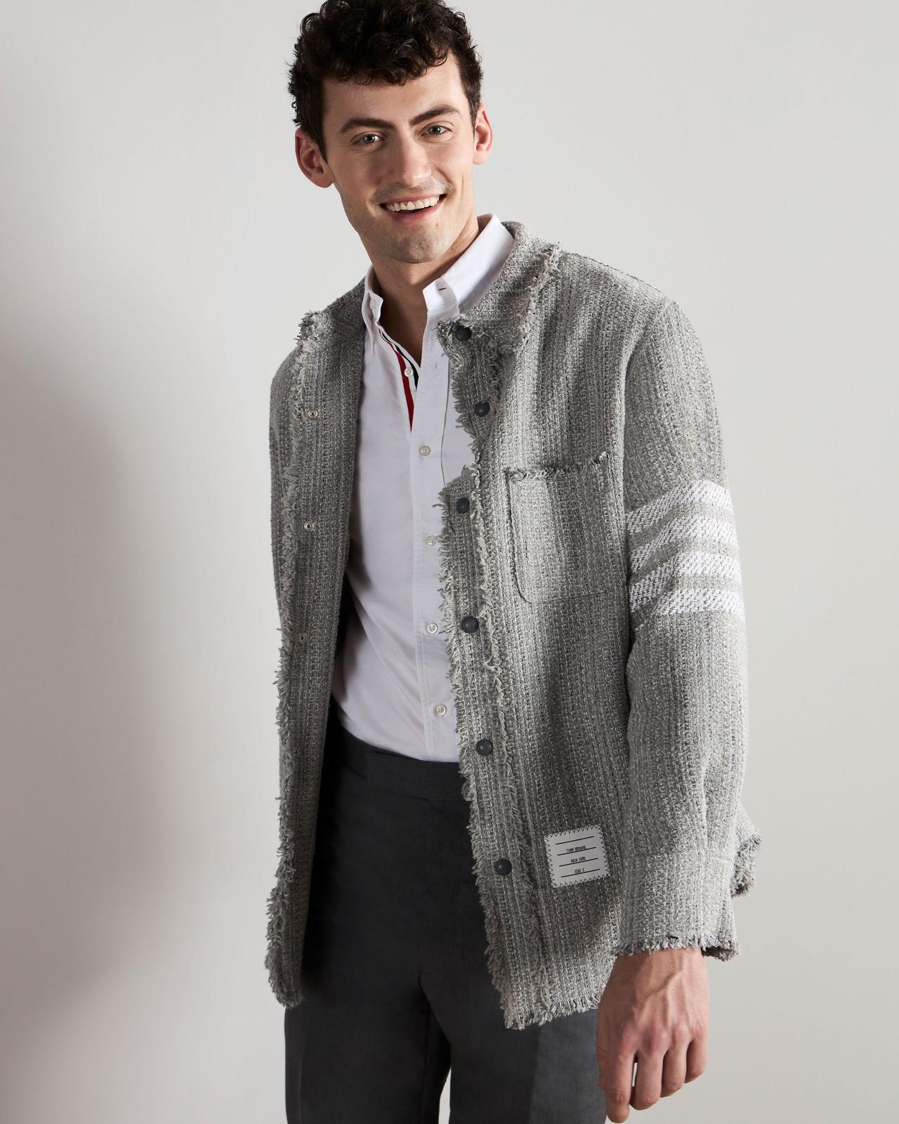 a man in a gray jacket and pants smiling