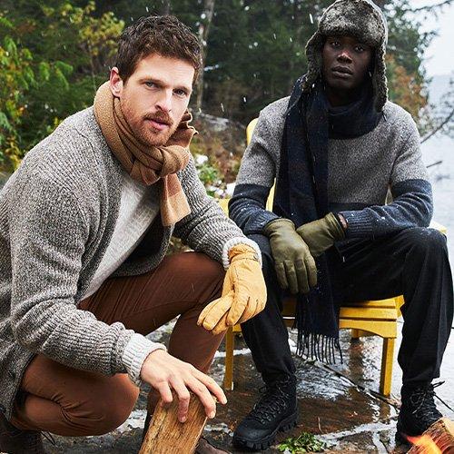 Two men seated, sporting winterwear and ski season accessories