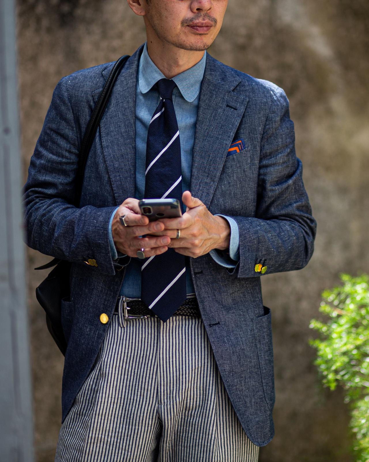 A man in a suit and tie holding a cell phone