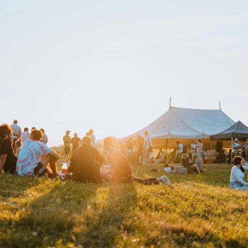 A scenery of a hilltop people sitting and enjoying together