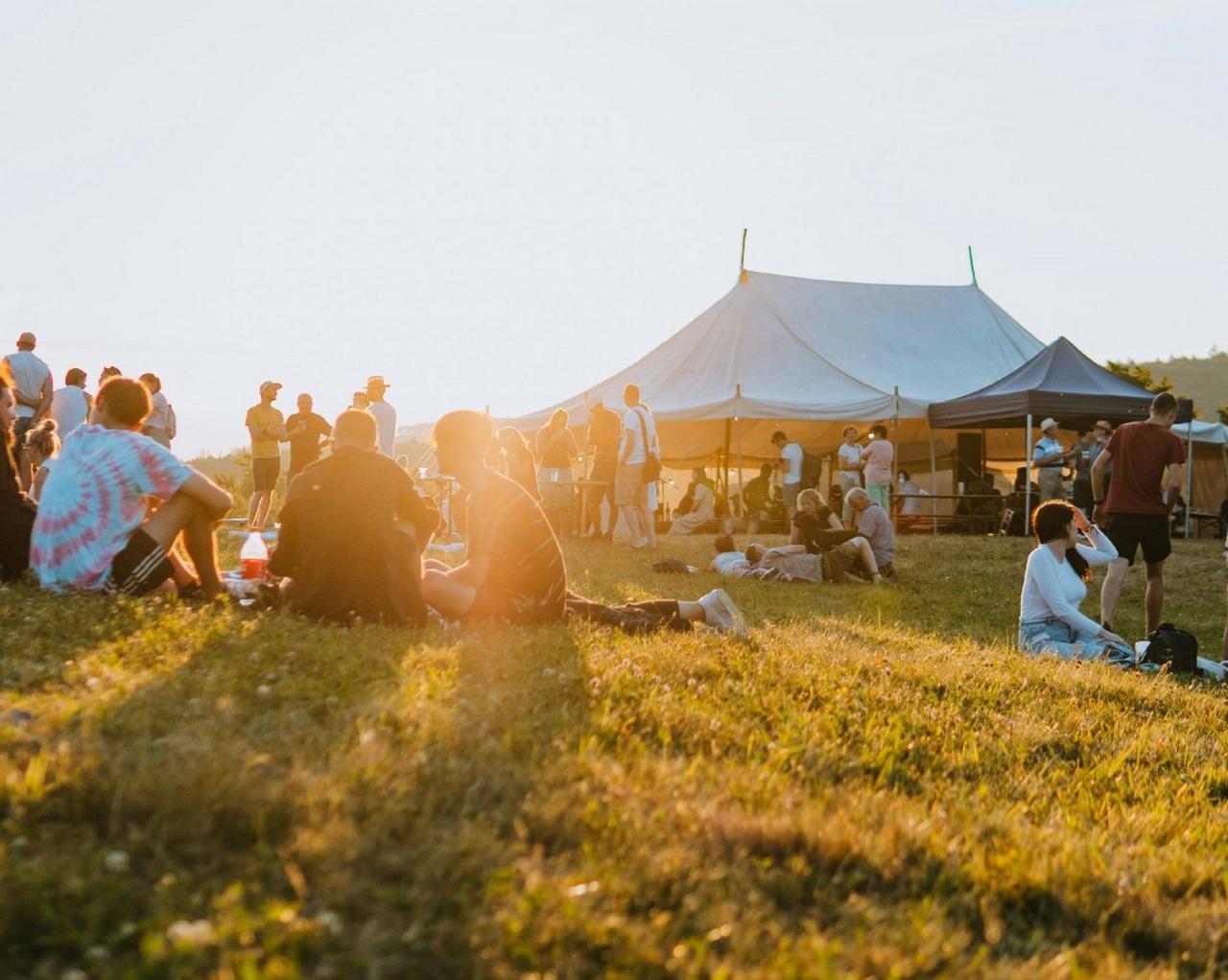 A scenery of a hilltop people sitting and enjoying together