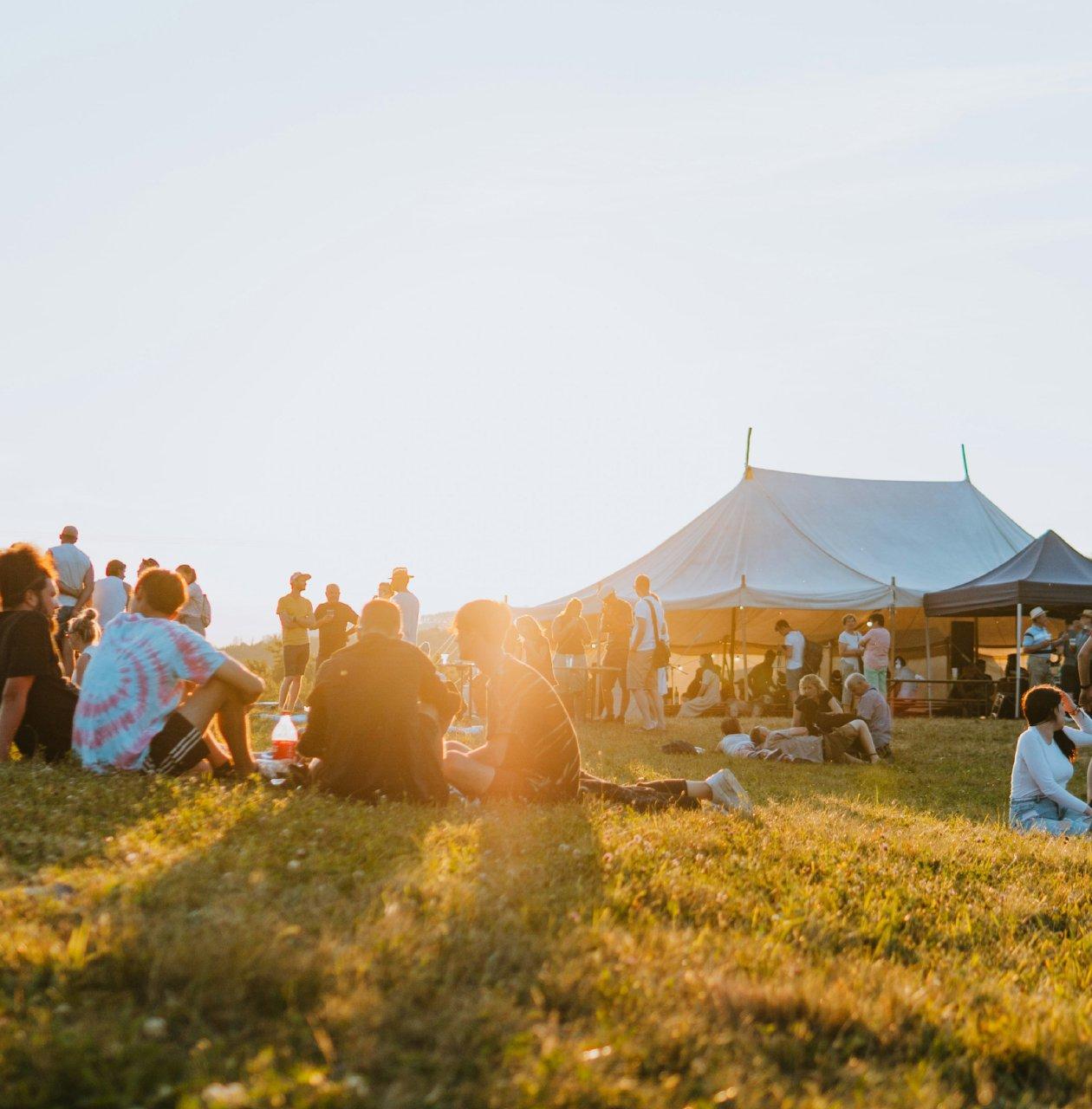 A scenery of a hilltop people sitting and enjoying together