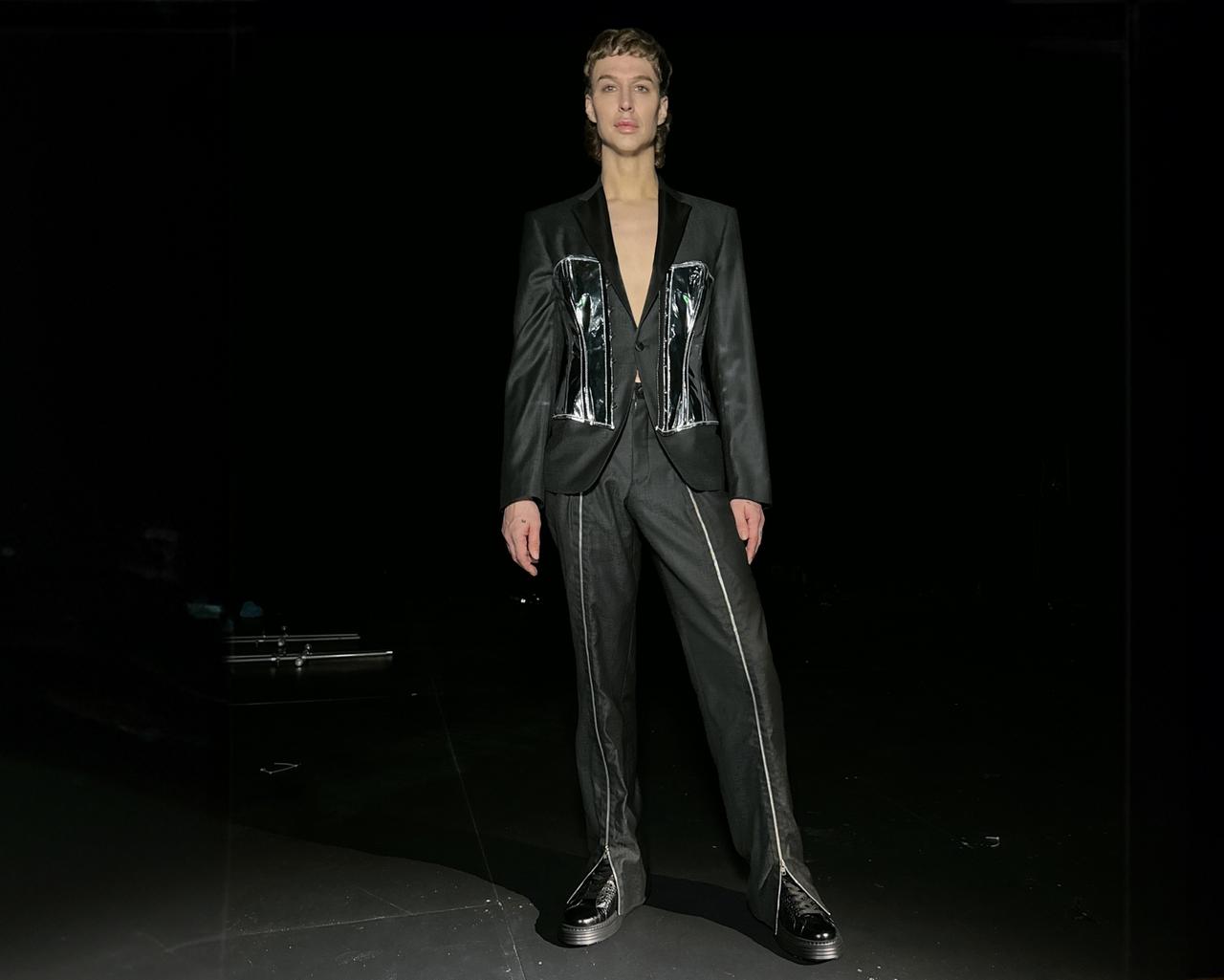 Brook Lyn Hytes wearing a black suit with a chrome corset