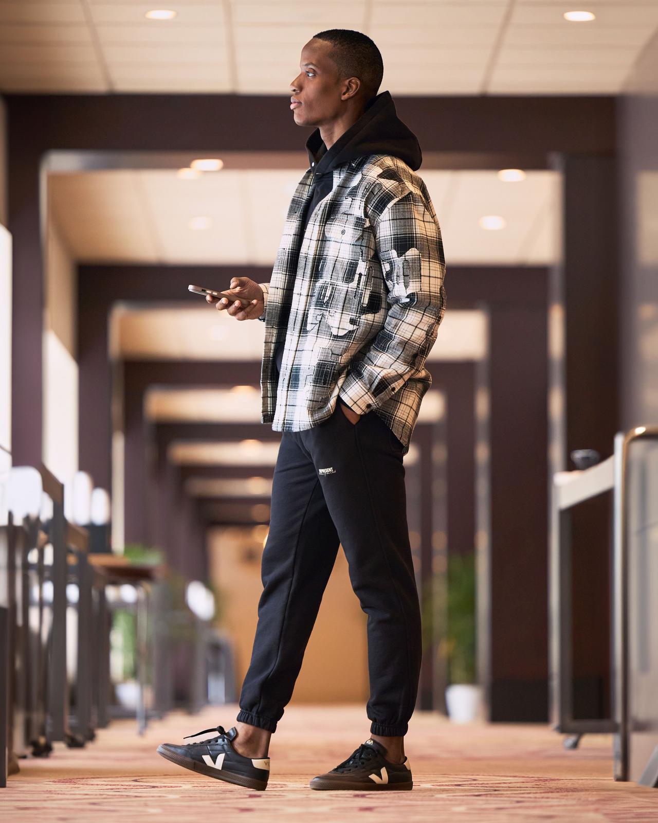 Male model wearing Purple Brand and Represent Spring inspired outfit signifying top trends for Spring '25