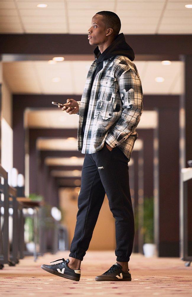 Male model wearing Purple Brand and Represent Spring inspired outfit signifying top trends for Spring '25