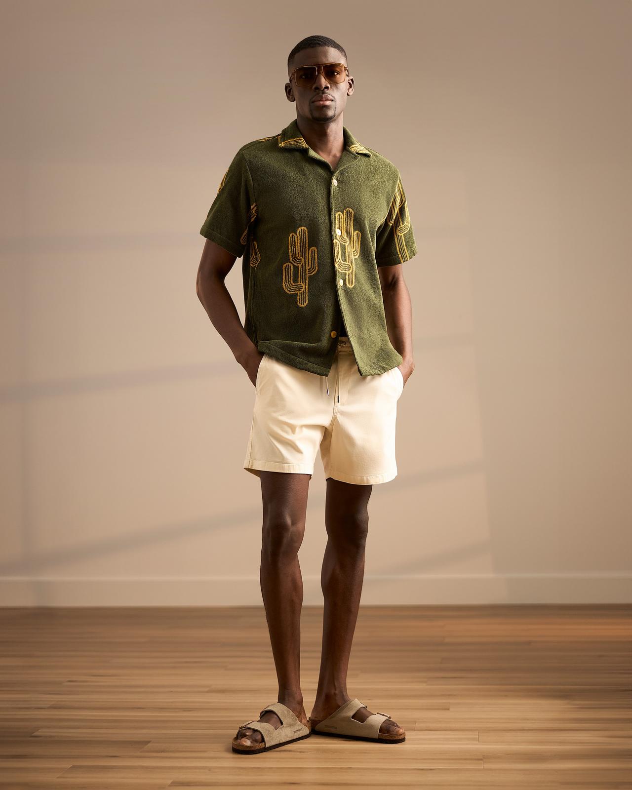 Male model wearing a cactus causal shirt with white shorts