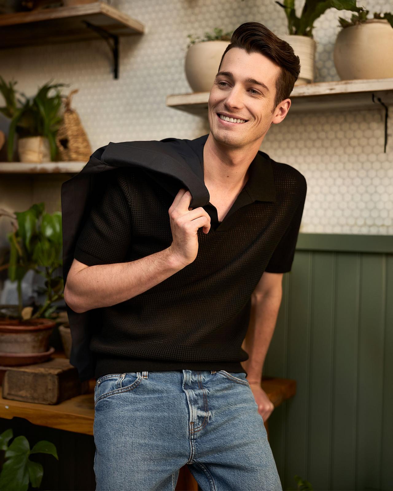 Male model wearing a black polo and jeans