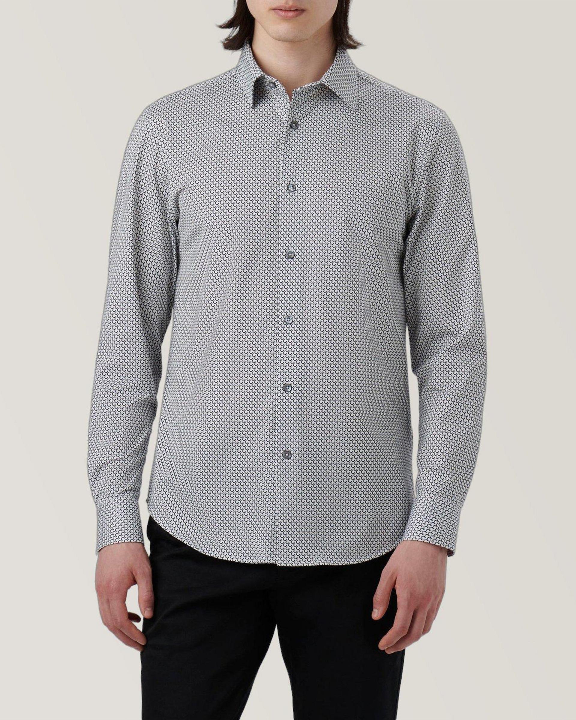 A man wearing a grey Patterned shirt and black pants