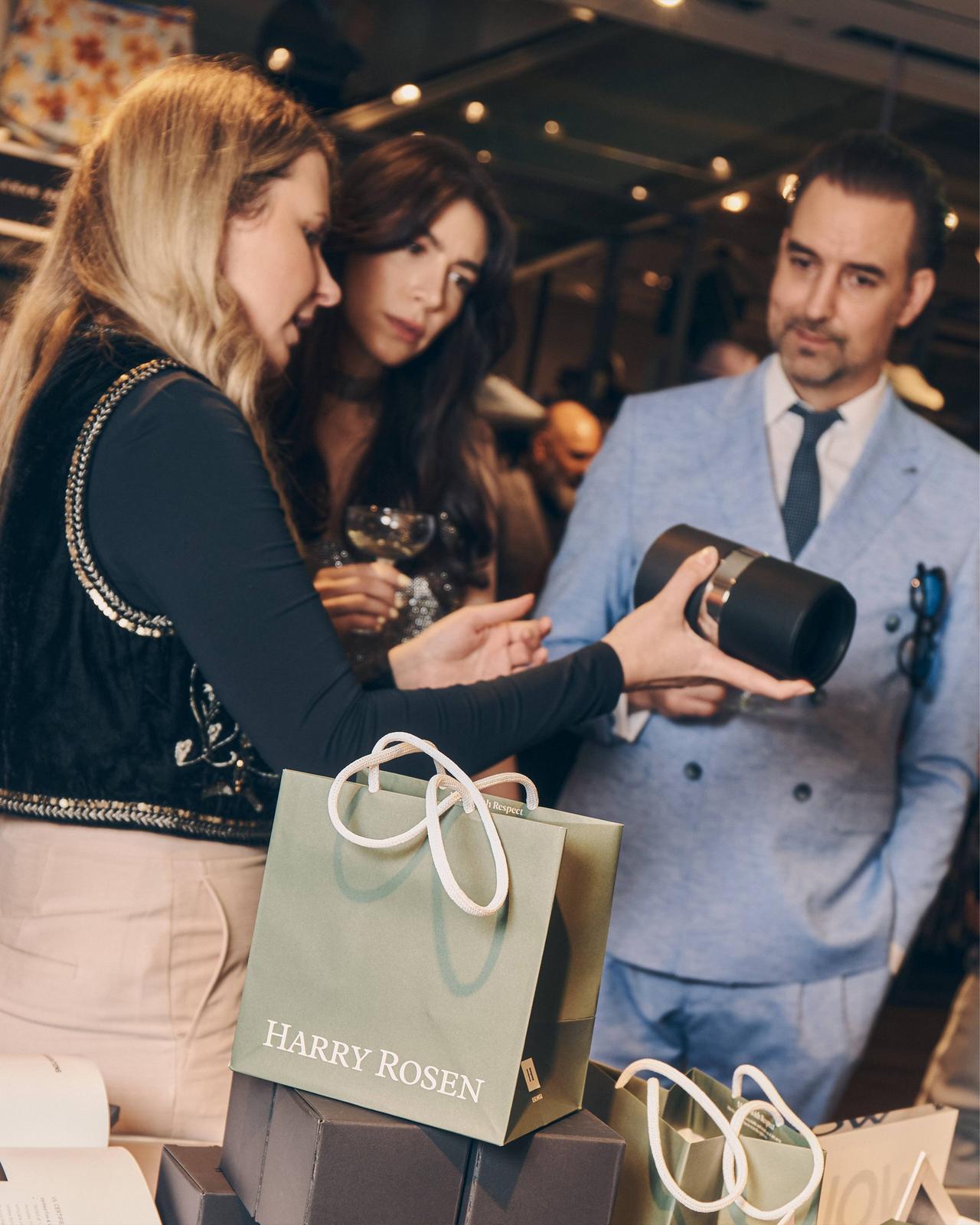 A group of people at Sharp X Harry Rosen event admiring a watch winder