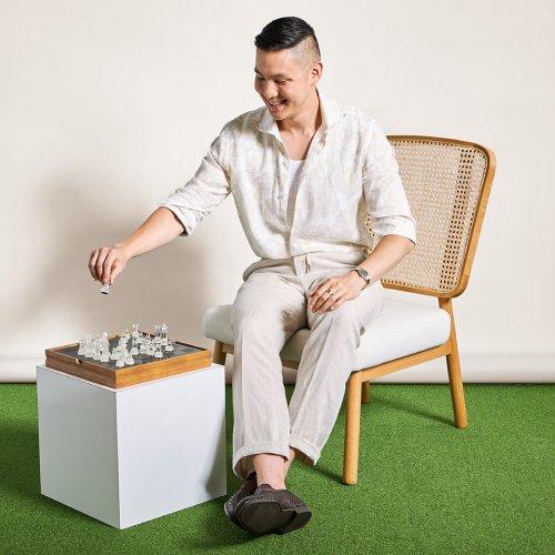 Male model wearing a white causal shirt playing chess