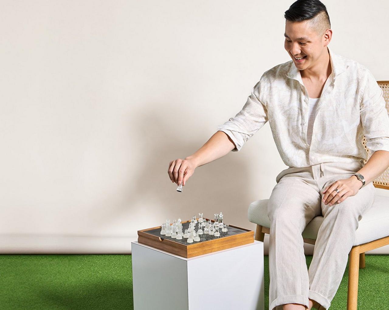 Male model wearing a white causal shirt playing chess