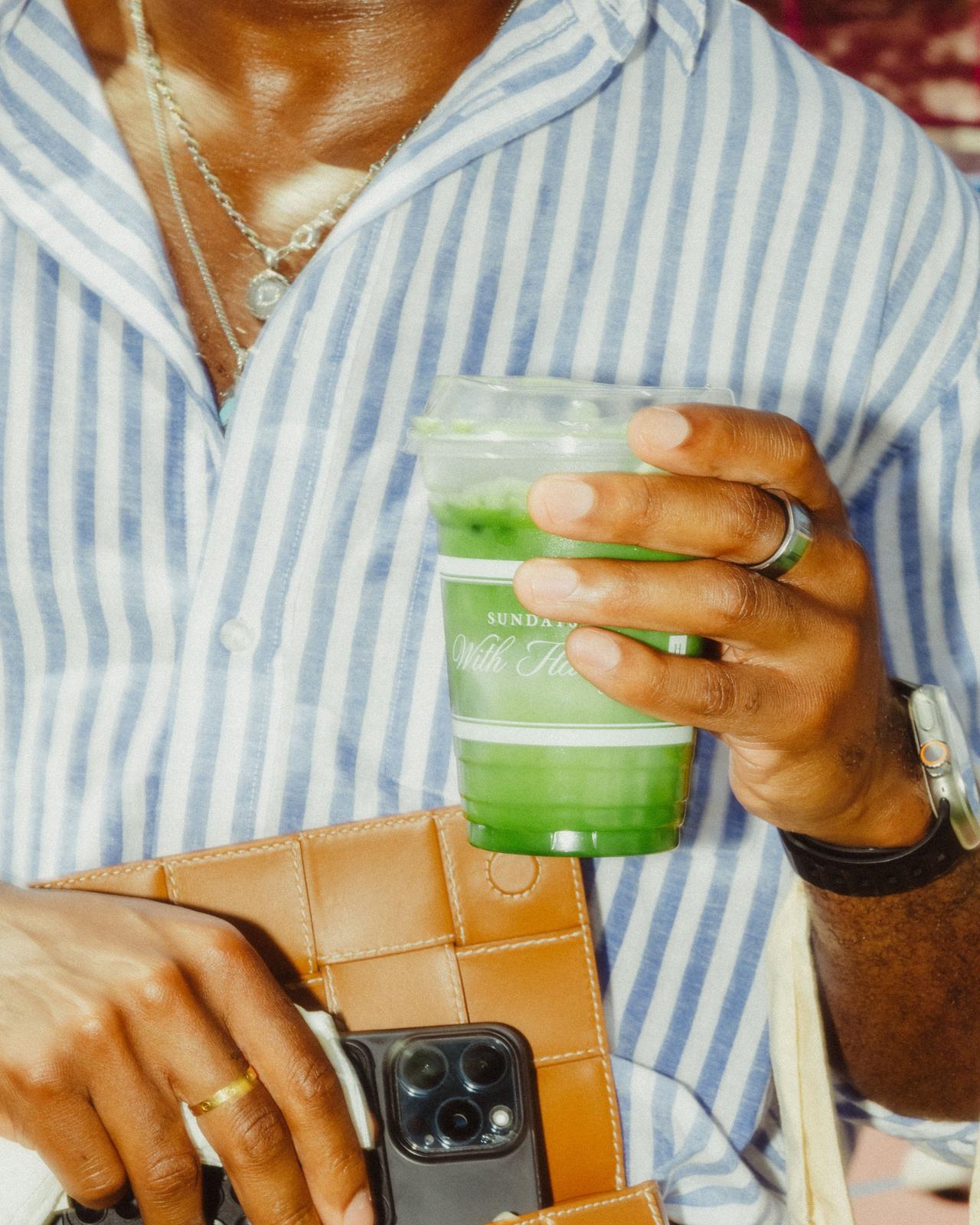 Un homme portant une chemise à rayures bleu pâle tenant un matcha