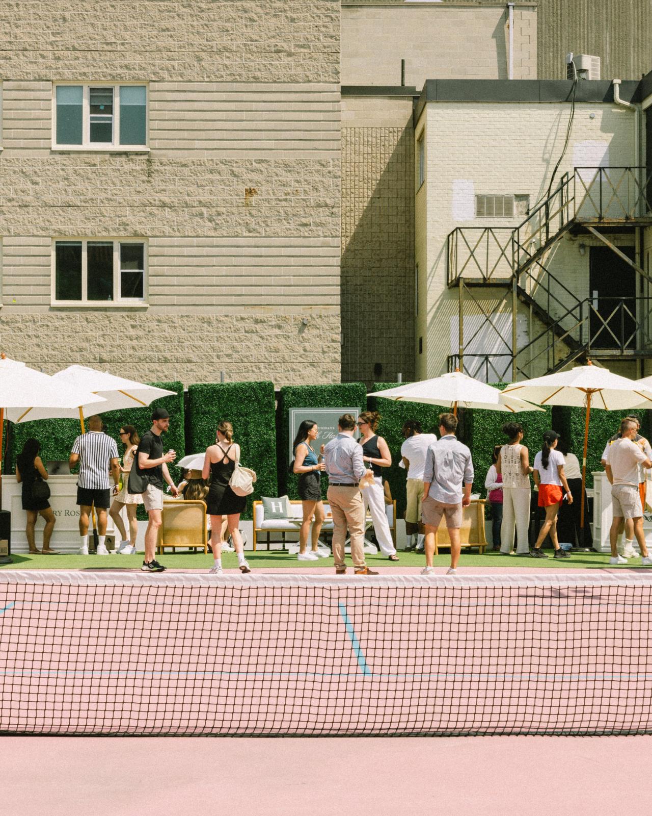 A man in a white T-shirt and shorts is reading Sundays with Harry magazine