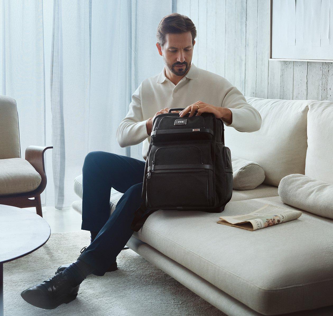 Male model opening a TUMI backpack