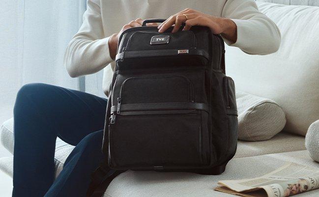 Male model opening a TUMI backpack