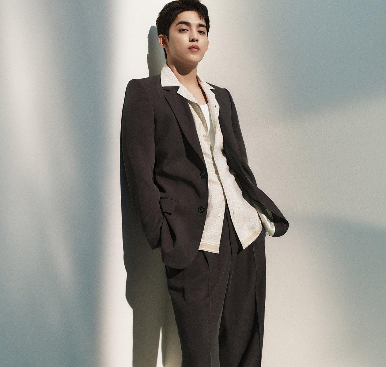 A male model wearing a black BOSS suit styled with a white dress shirt