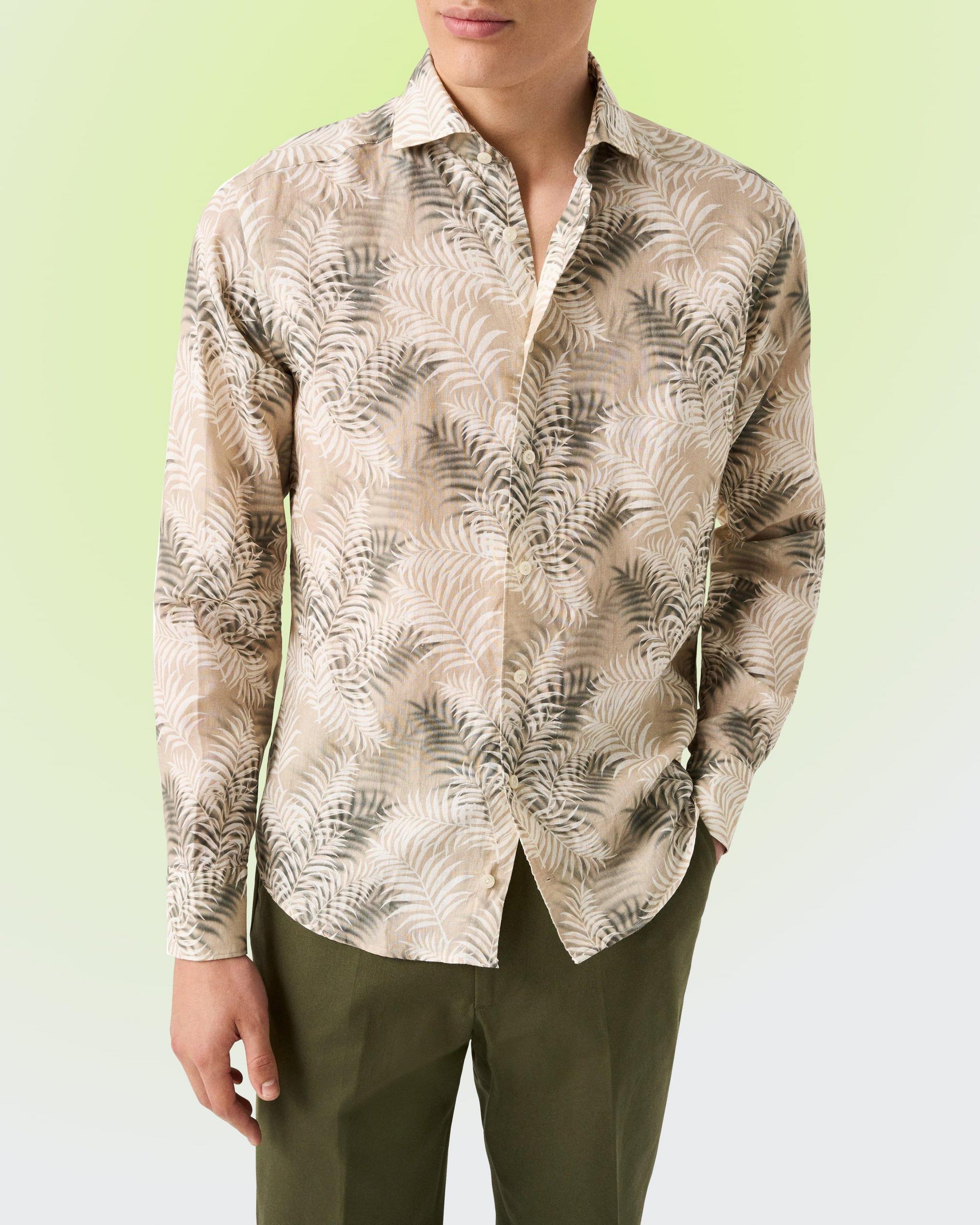 Model wearing Eton Motif Linen Shirt in a beige leaf print and green pant