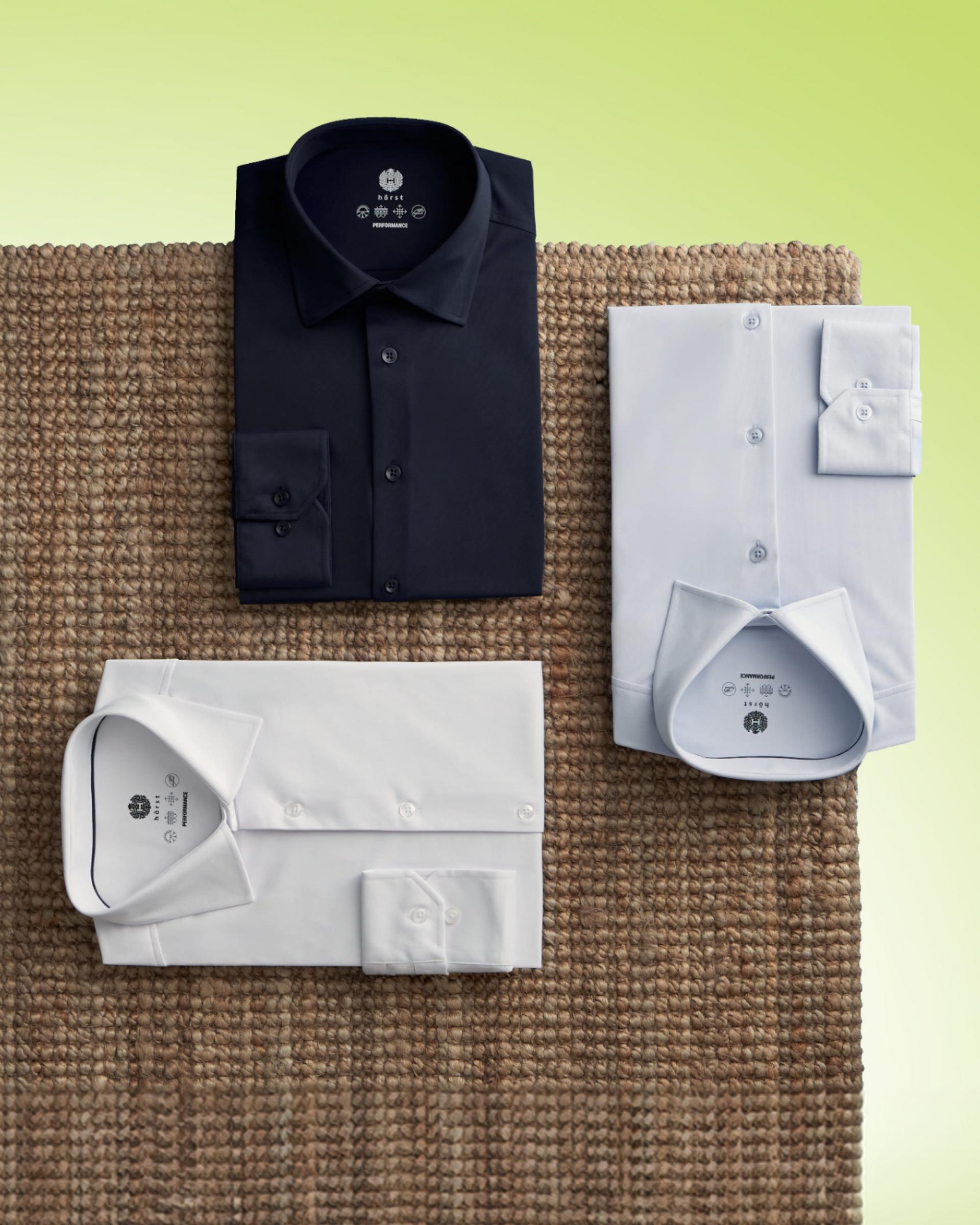a brown table with three dress shirts folded