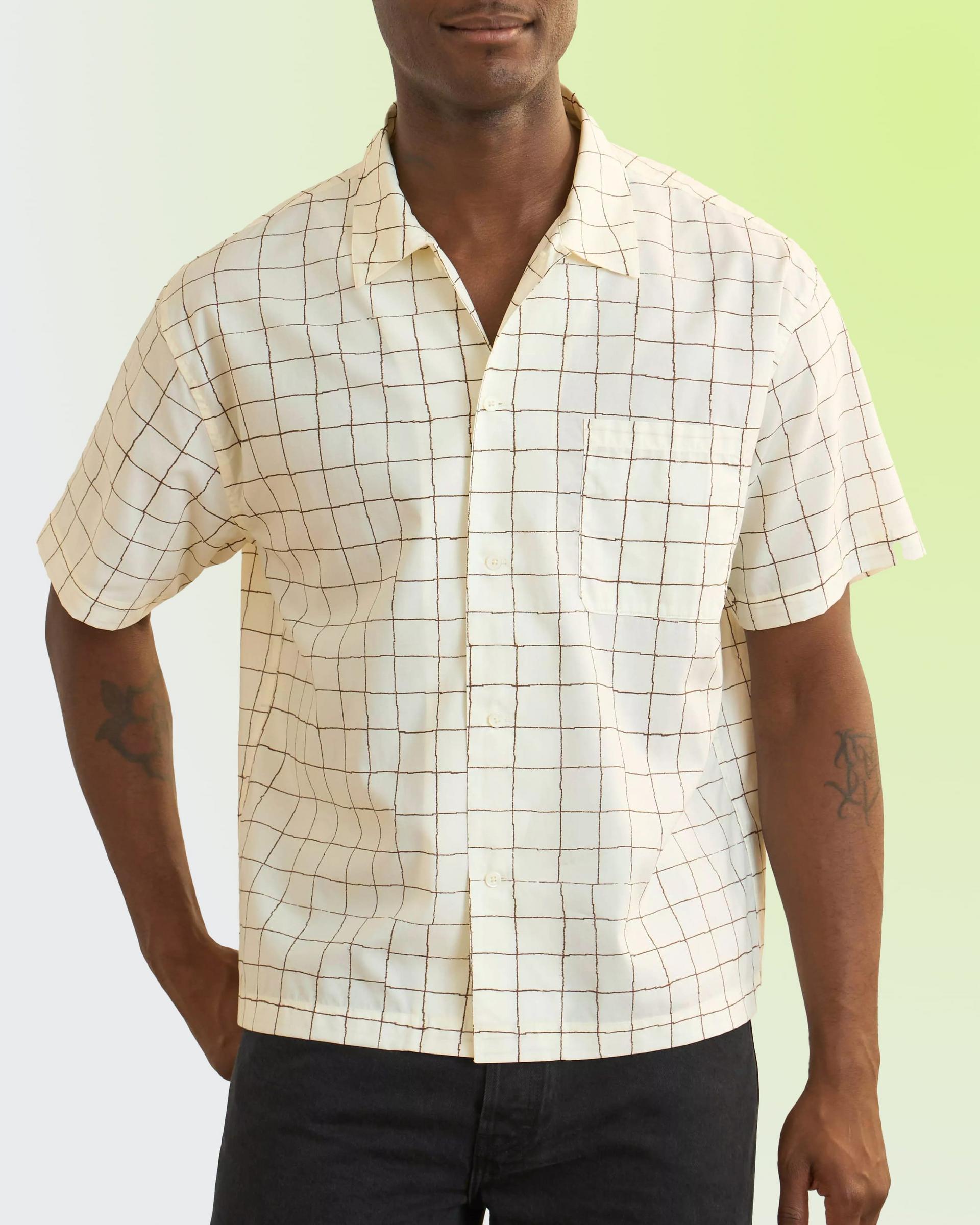 A man wearing an off-white and brown Check patterned shirt