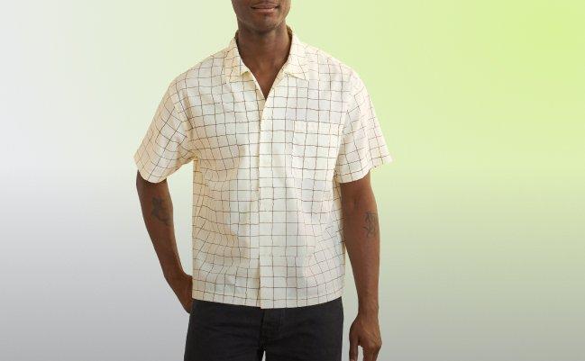 Un homme portant une chemise à carreaux brun et blanc cassé