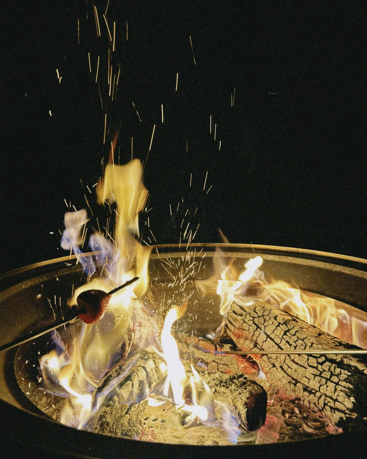 The fire pit is lit with a warm, glowing fire