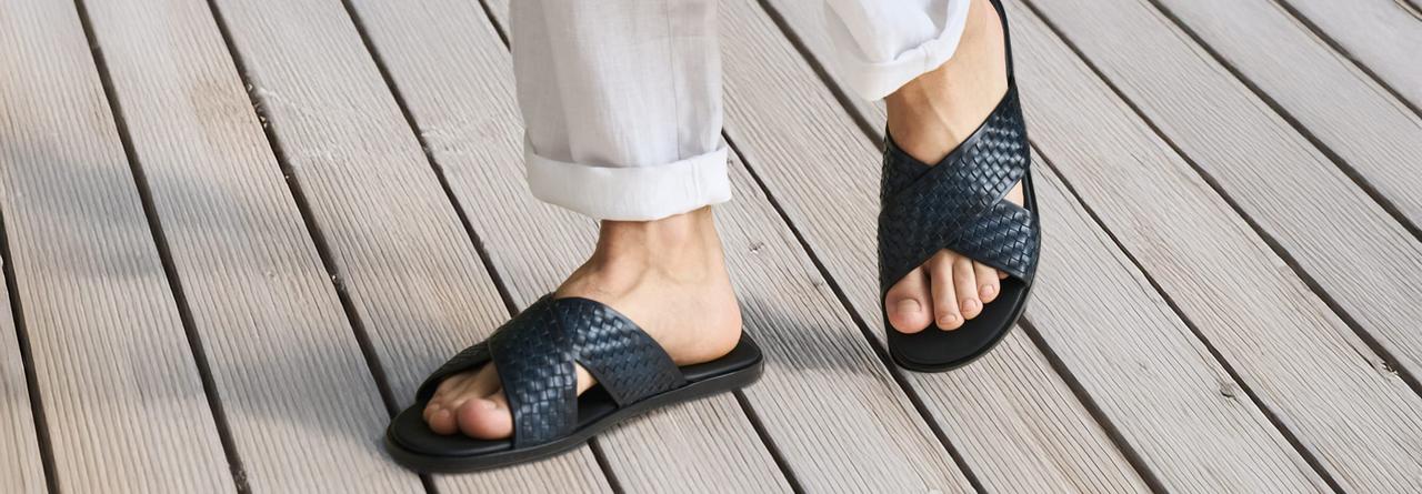 A person wearing the Cross Strap Slide Sandal in black