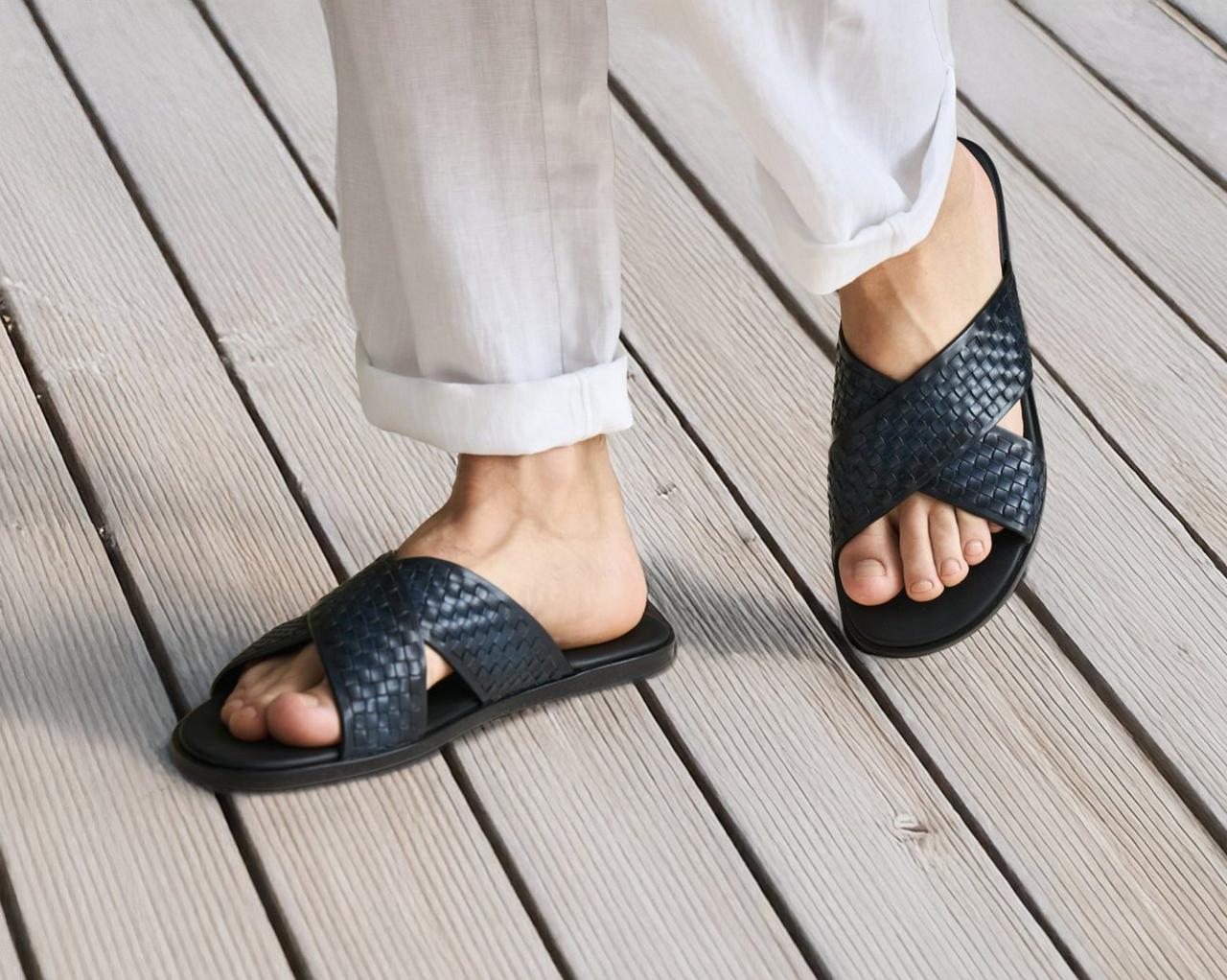 A person wearing the Cross Strap Slide Sandal in black