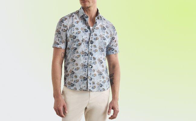 mannequin portant une chemise boutonnée à manches courtes bleu clair avec un motif floral marron et bleu, associée à un pantalon beige clair